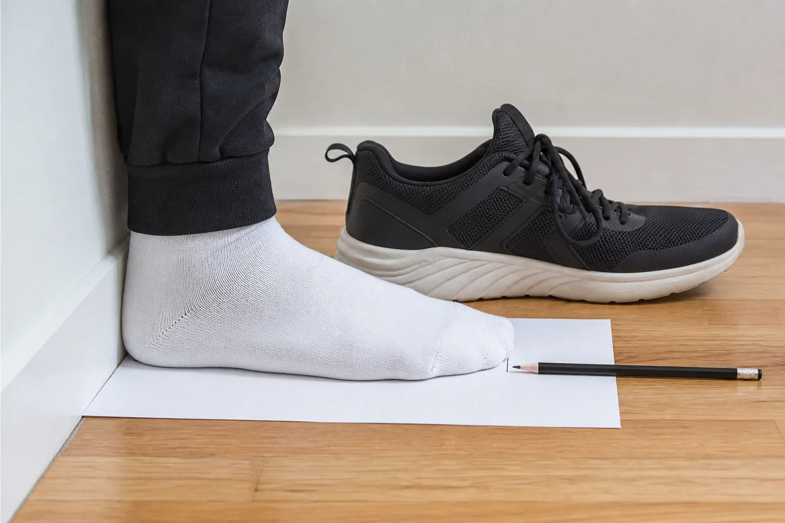 Fotens längd mäts med hälen mot en vägg inför val av Nike storlek